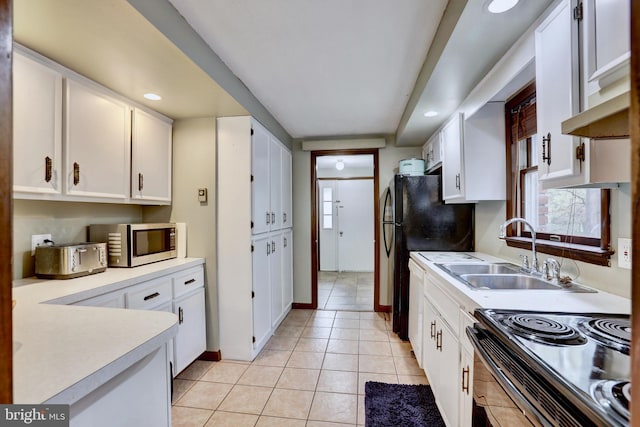 kitchen with sink, black appliances, white cabinetry, and light tile patterned floors