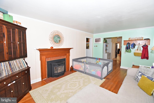 bedroom with hardwood / wood-style flooring, ornamental molding, and a wood stove