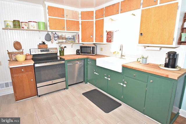 kitchen with wooden counters, sink, and appliances with stainless steel finishes