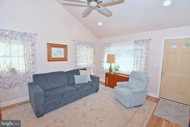 living room with high vaulted ceiling, light wood-type flooring, and ceiling fan