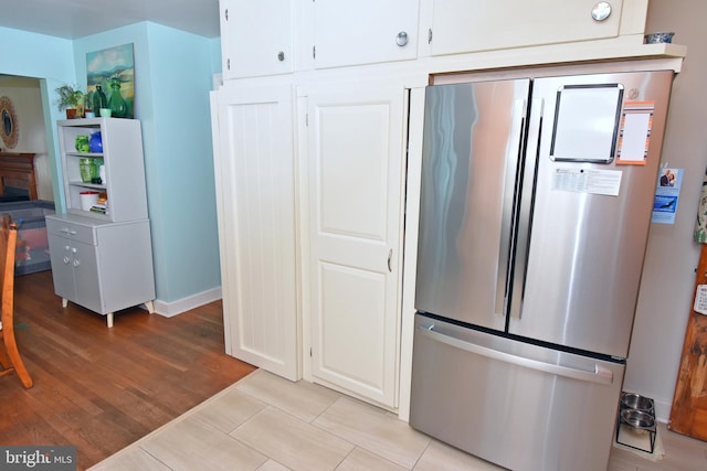 kitchen featuring white cabinetry, light hardwood / wood-style flooring, and stainless steel fridge