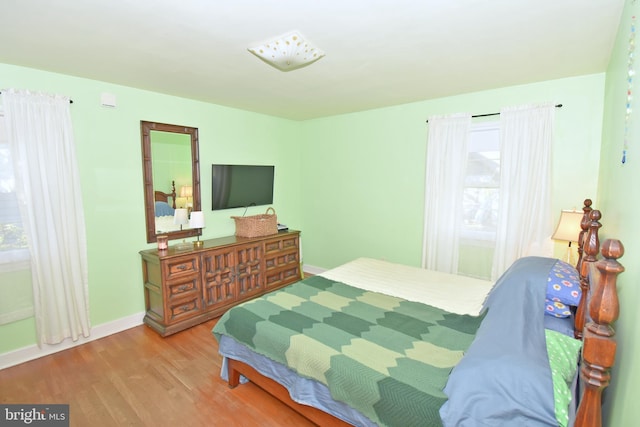 bedroom with hardwood / wood-style flooring and multiple windows