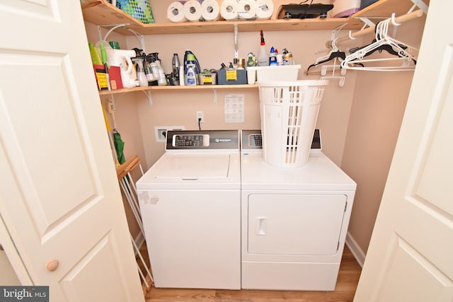 clothes washing area featuring light hardwood / wood-style floors and washing machine and dryer