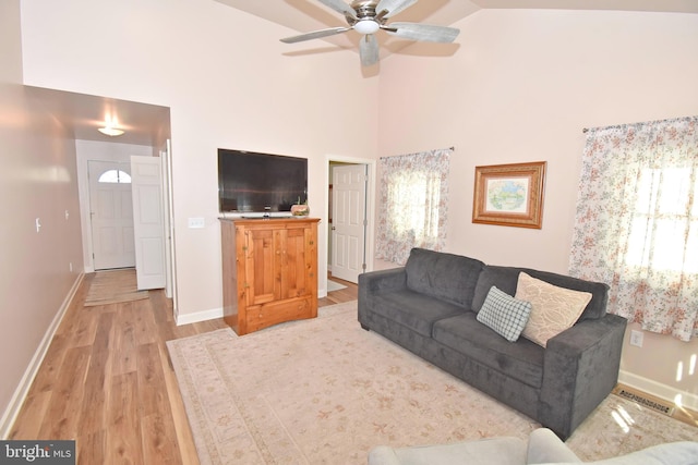 living room with light hardwood / wood-style floors, high vaulted ceiling, and ceiling fan