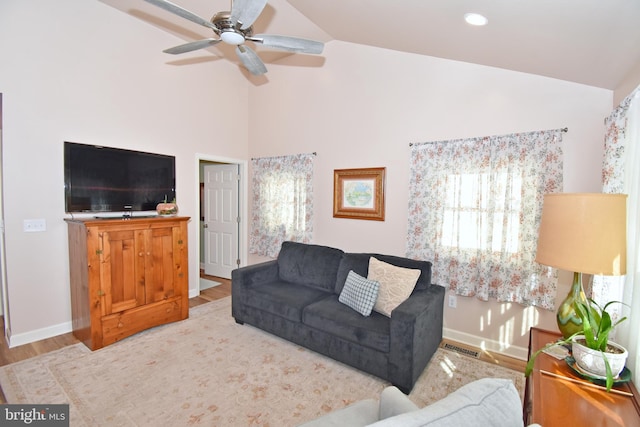 living room featuring ceiling fan, wood-type flooring, and vaulted ceiling