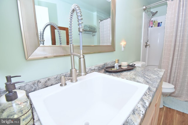 bathroom with vanity, hardwood / wood-style flooring, toilet, and walk in shower