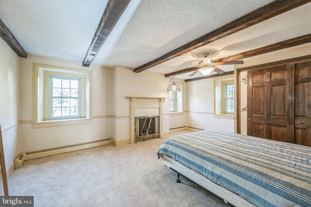 carpeted bedroom featuring ceiling fan, a textured ceiling, beamed ceiling, and baseboard heating