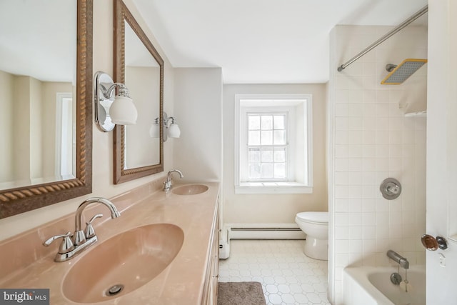 full bathroom with tiled shower / bath, a baseboard radiator, toilet, vanity, and tile patterned flooring