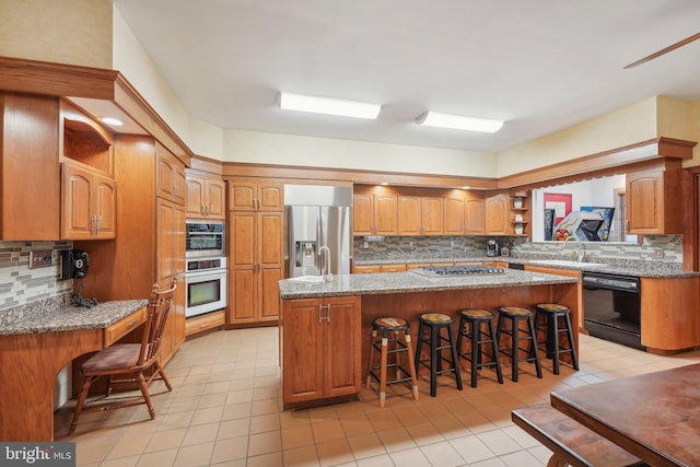 kitchen with backsplash, a breakfast bar, a center island, and stainless steel appliances