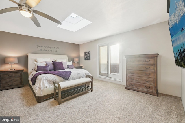 carpeted bedroom with a skylight and ceiling fan