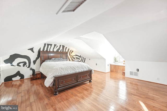 bedroom featuring light hardwood / wood-style floors and lofted ceiling