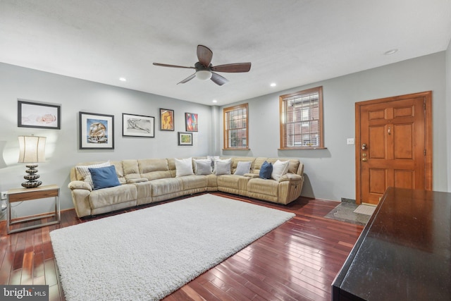 living room with dark hardwood / wood-style flooring and ceiling fan