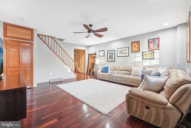 living room with ceiling fan and dark wood-type flooring