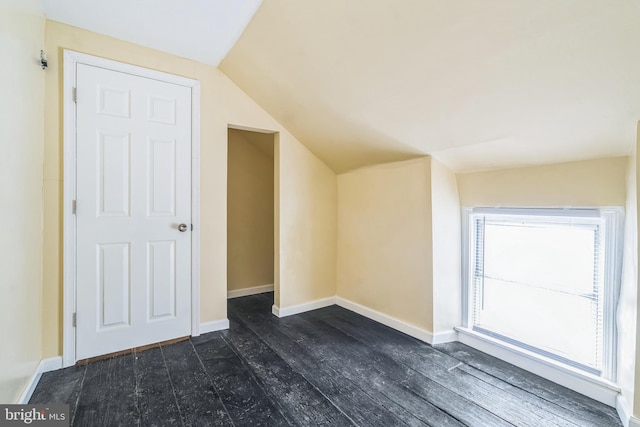 additional living space featuring lofted ceiling and dark hardwood / wood-style flooring