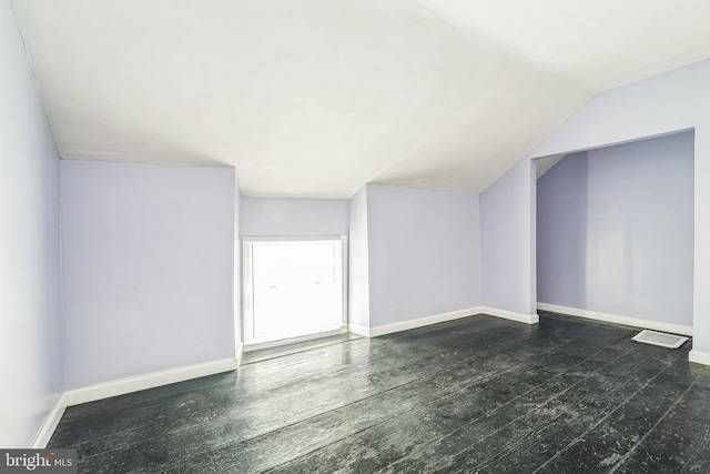 additional living space with lofted ceiling and dark hardwood / wood-style floors