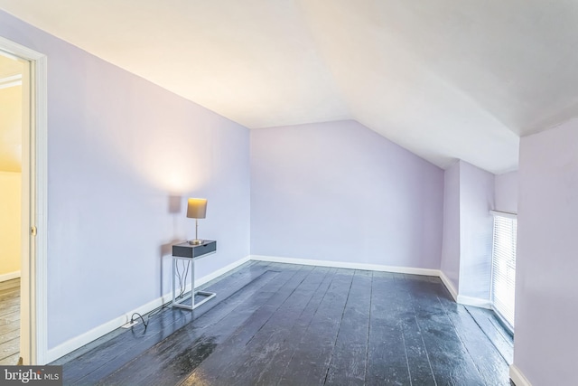 additional living space featuring vaulted ceiling and dark hardwood / wood-style floors