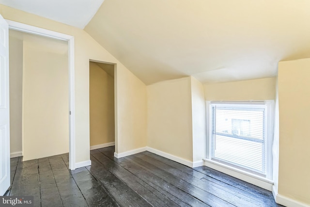 additional living space with dark hardwood / wood-style floors and vaulted ceiling