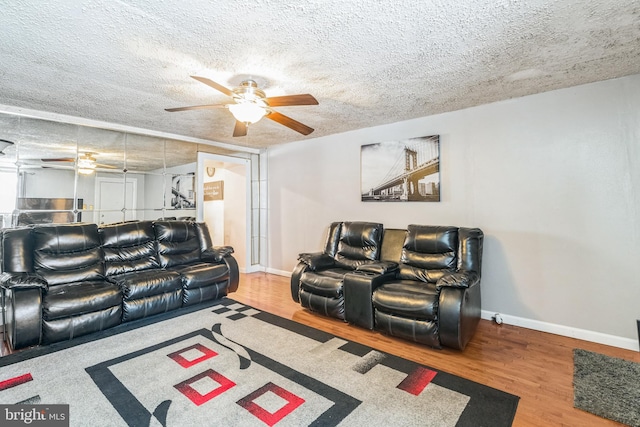 living room featuring a textured ceiling, hardwood / wood-style flooring, and ceiling fan