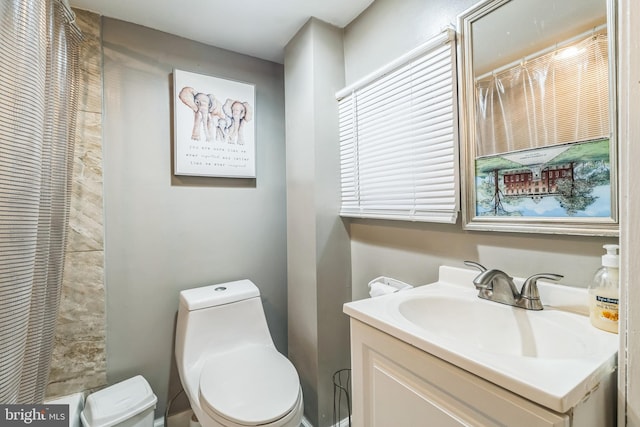 bathroom featuring vanity, toilet, and walk in shower