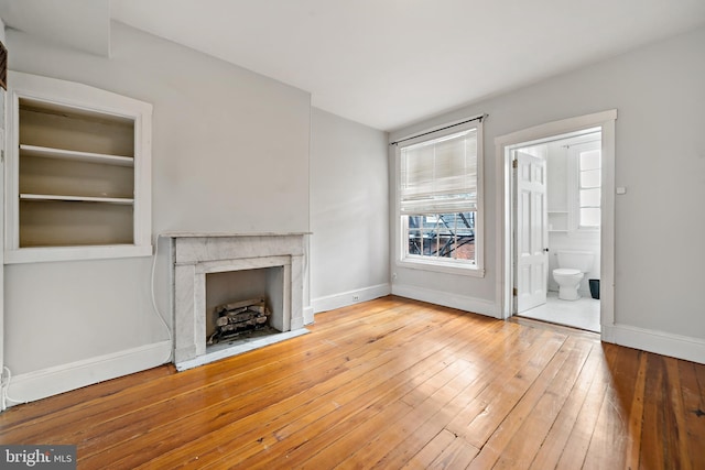 unfurnished living room featuring a fireplace and wood-type flooring