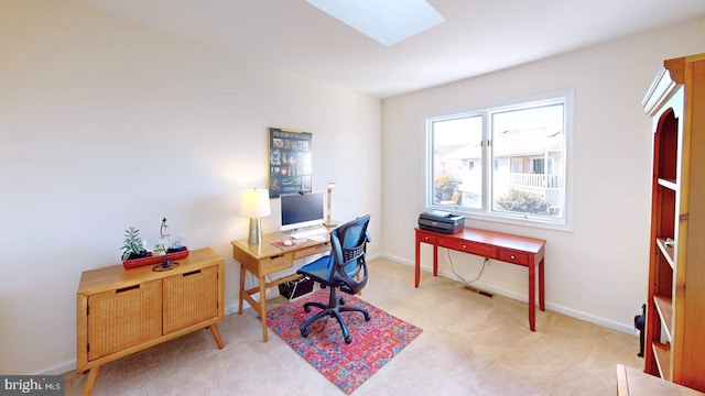 carpeted office featuring a skylight