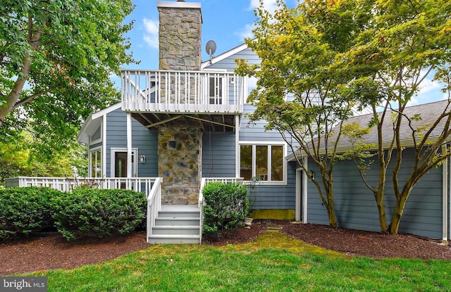 rear view of property with a deck and a lawn