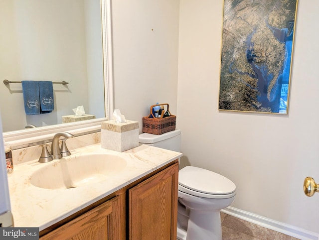 bathroom with toilet, vanity, and tile patterned floors