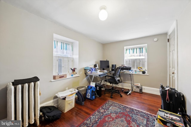 office with radiator and dark hardwood / wood-style flooring