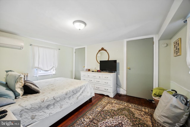 bedroom featuring a wall mounted air conditioner and dark hardwood / wood-style flooring