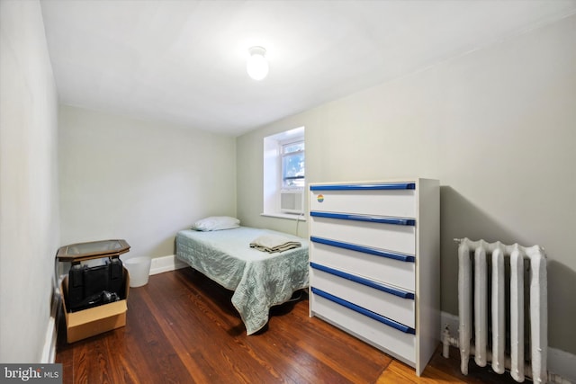 bedroom featuring radiator heating unit and dark hardwood / wood-style floors