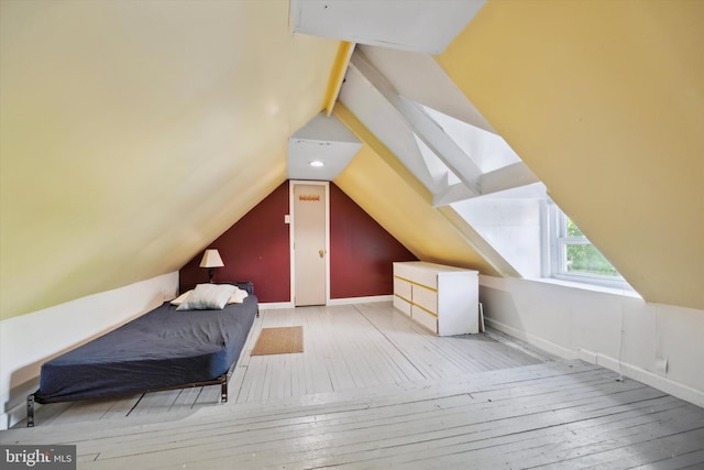 bedroom with light hardwood / wood-style floors and vaulted ceiling with skylight