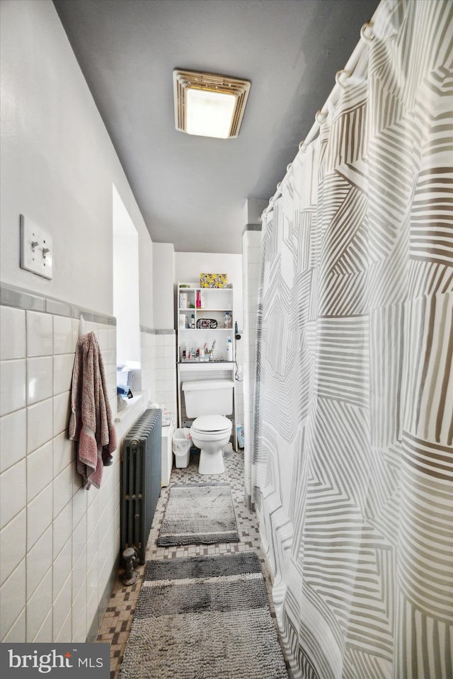 bathroom featuring toilet, tile walls, radiator heating unit, and tile patterned flooring