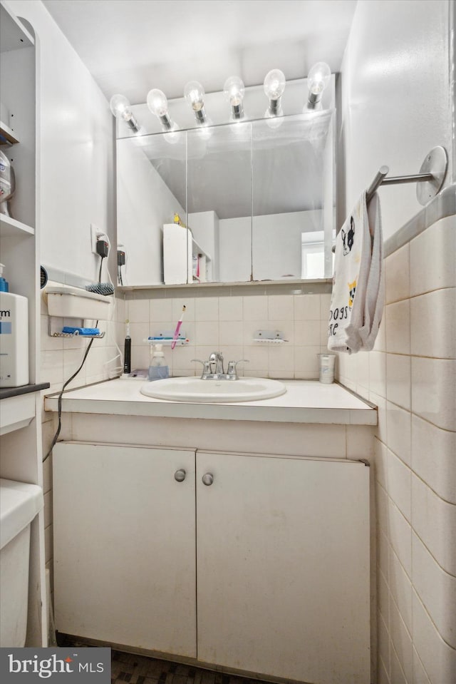 bathroom featuring vanity, decorative backsplash, and toilet