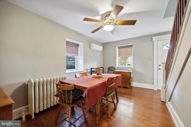 dining room featuring radiator, ceiling fan, wood-type flooring, and a wall unit AC