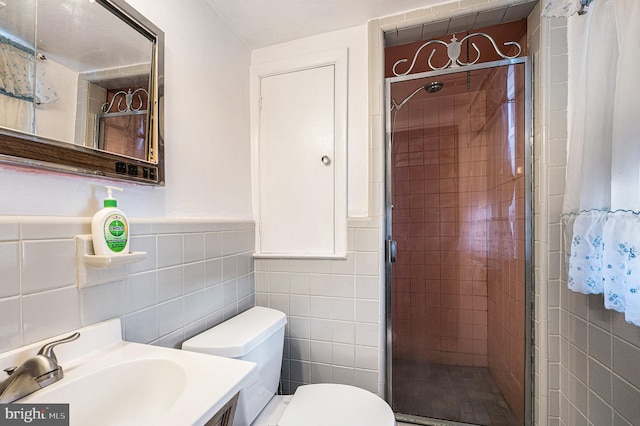 bathroom with vanity, an enclosed shower, tile walls, and toilet