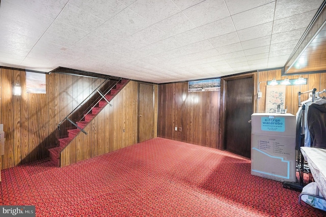 basement with carpet flooring and wood walls