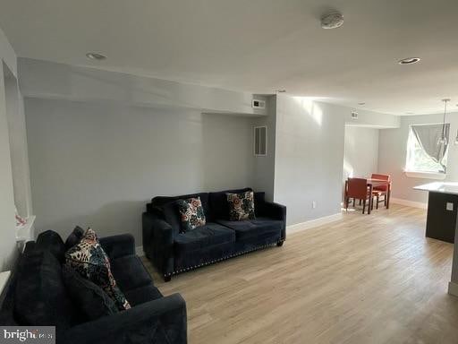 living room with wood-type flooring and a notable chandelier