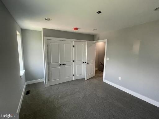 unfurnished bedroom featuring dark colored carpet