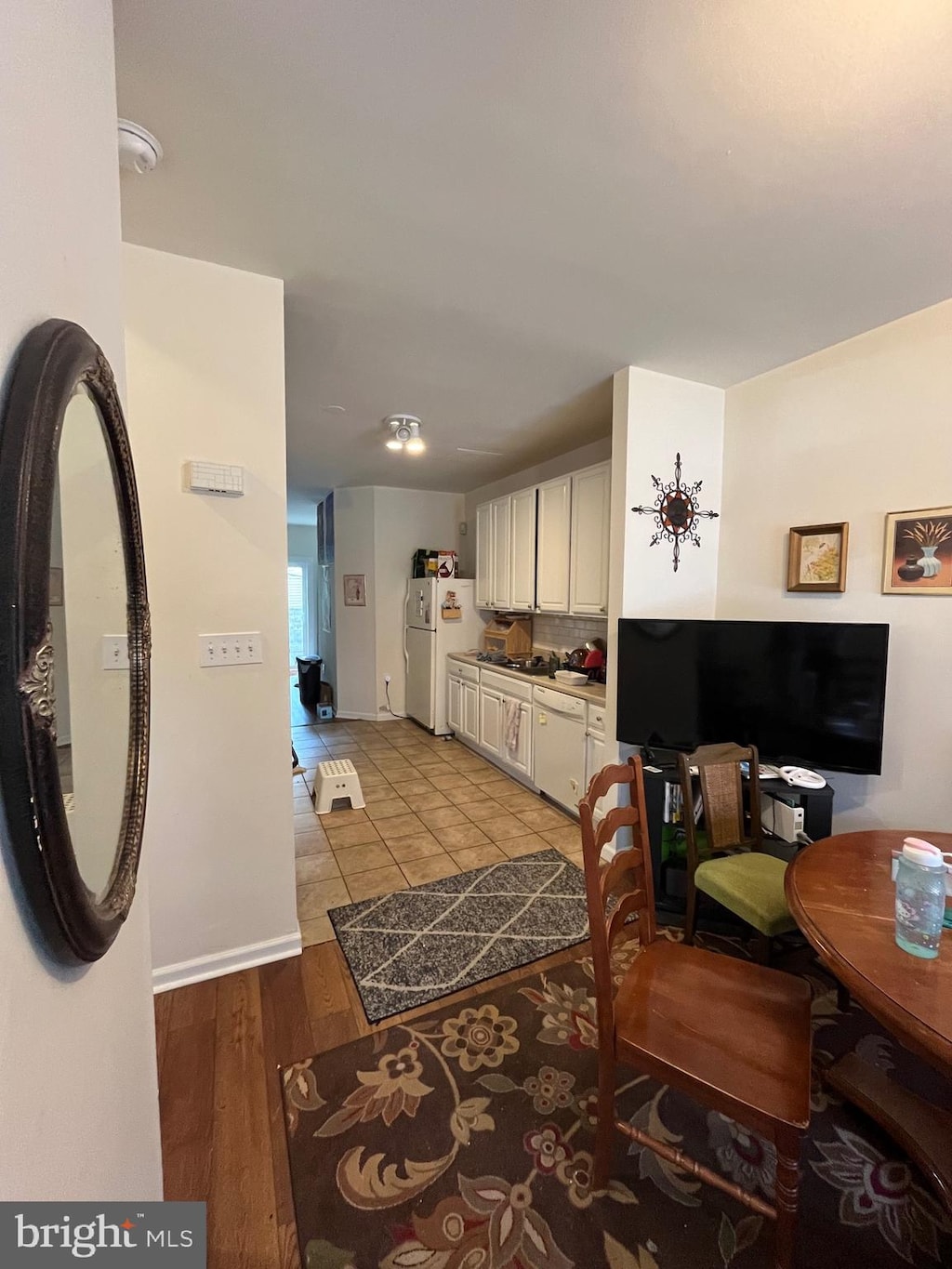 kitchen with light hardwood / wood-style flooring, white appliances, and white cabinets