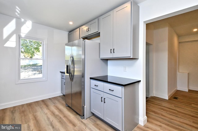 kitchen with light hardwood / wood-style flooring and stainless steel fridge