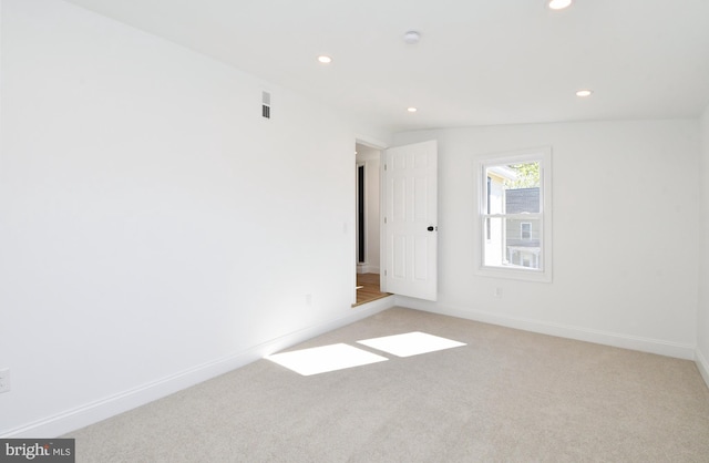 carpeted spare room with lofted ceiling