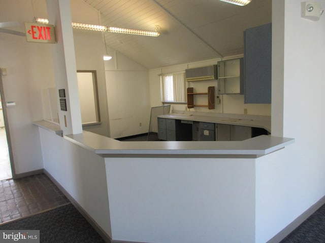 kitchen featuring gray cabinets, vaulted ceiling, and kitchen peninsula