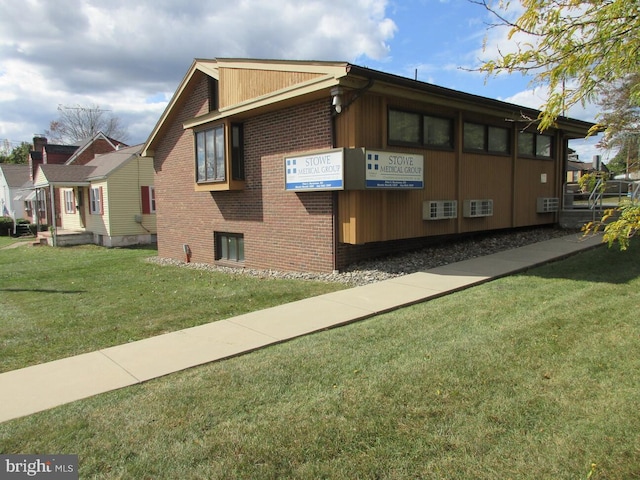 view of side of home with a yard and brick siding