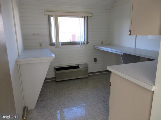kitchen with light countertops, lofted ceiling, and heating unit