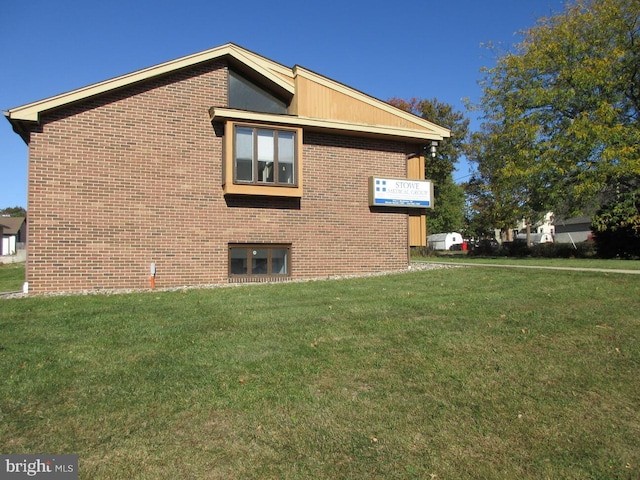 view of home's exterior with a yard and brick siding