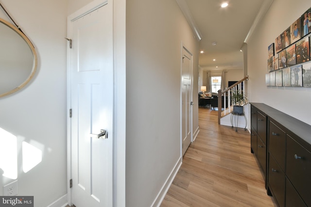 corridor with crown molding and light hardwood / wood-style floors