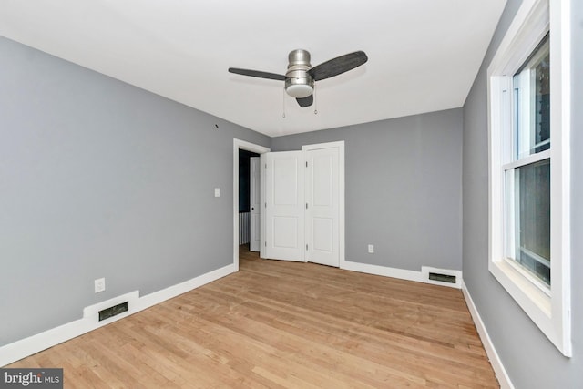 unfurnished bedroom featuring light hardwood / wood-style flooring, ceiling fan, and a closet