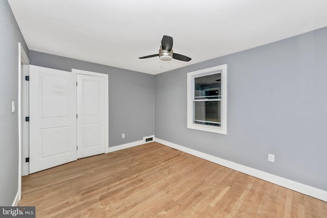 unfurnished bedroom featuring light hardwood / wood-style floors, ceiling fan, and a closet