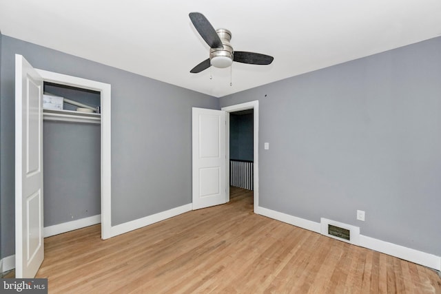 unfurnished bedroom with light wood-type flooring, ceiling fan, and a closet