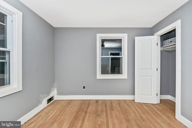 unfurnished bedroom with a closet and light hardwood / wood-style floors